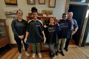 On the Road Collaborative students pose with Gaines Group T-shirts with Charles and Asha.